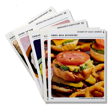 Assorted recipe cards from the Betty Crocker Recipe Card Library. The front card is the front of the Green Bean Bunwiches recipe with an image of the dish.