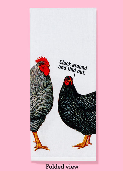 Folded dishtowel with the text CLUCK AROUND AND FIND OUT featuring vintage illustrations of a rooster and a hen.