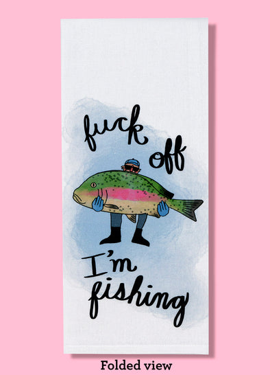 Folded dishtowel with the text FUCK OFF I'M FISHING featuring an illustration of a fisherman with a massive rainbow trout.