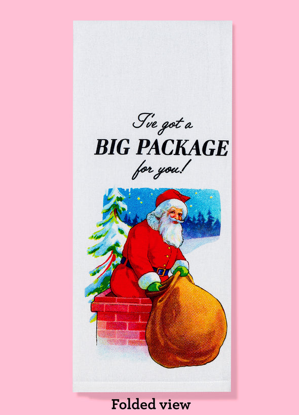 The "I've Got a Big Package For You!" dishtowel, shown folded into thirds. It features the text as well as an illustration of Santa Claus holding a large cloth sack.