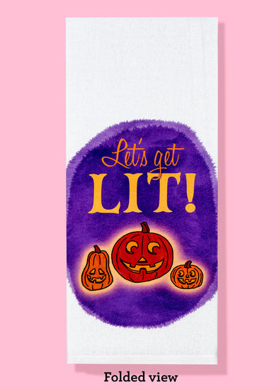 Folded view of Bad Grandma Designs dishtowel featuring three sassy Jack O Lanterns and the phrase LETS GET LIT.