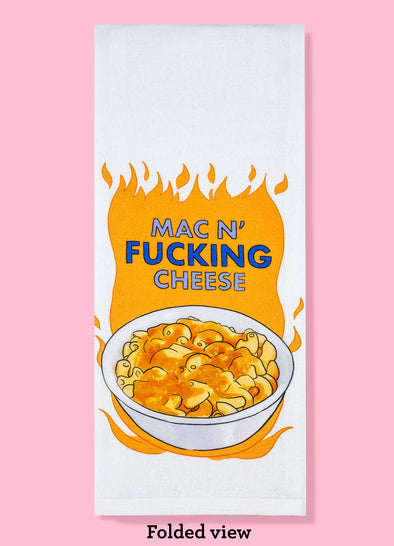 The folded view of the "Mac N' Fucking Cheese". The towel features the phrase with an illustration of a bowl of macaroni and cheese with illustrated flames around it 