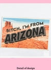 Close-up image of a dishtowel with the phrase Bitch, I'm From Arizona and an illustration of a postcard with Arizona scenery.