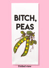Folded dishtowel with the phrase Bitch, Peas and an illustration of peas in a pod.
