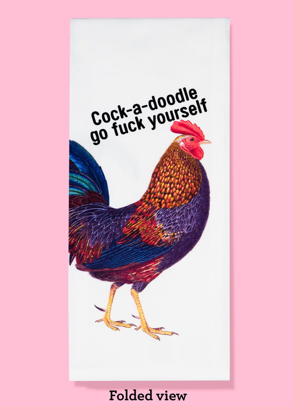 Folded dishtowel with an illustration of a rooster along with the phrase Cock A Doodle Go Fuck Yourself.