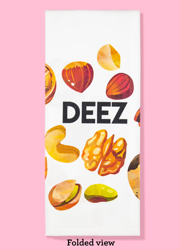 Folded dishtowel with illustration of shelled tree nuts and the phrase Deez.