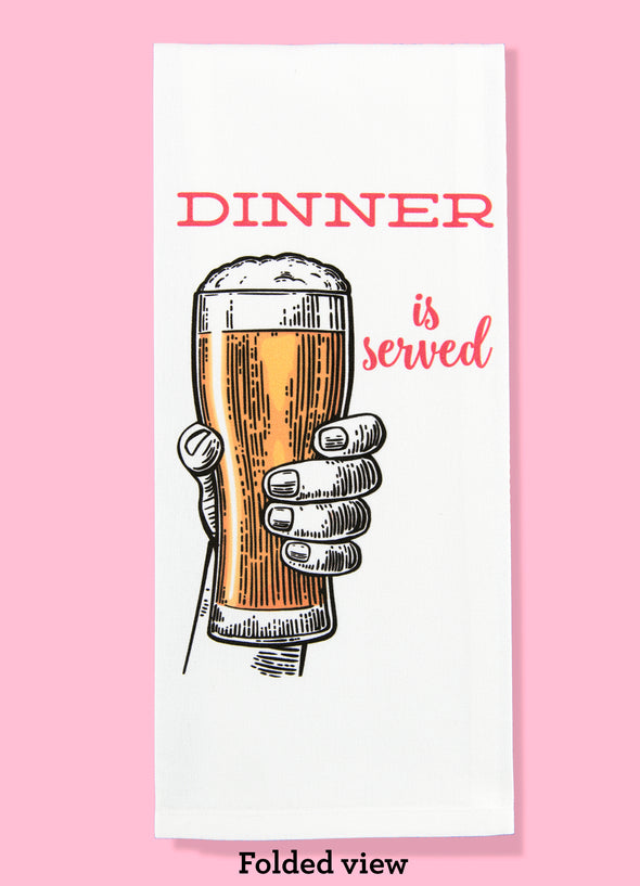 Folded dishtowel with an illustration of a hand holding a glass of beer and the phrase Dinner is Served.