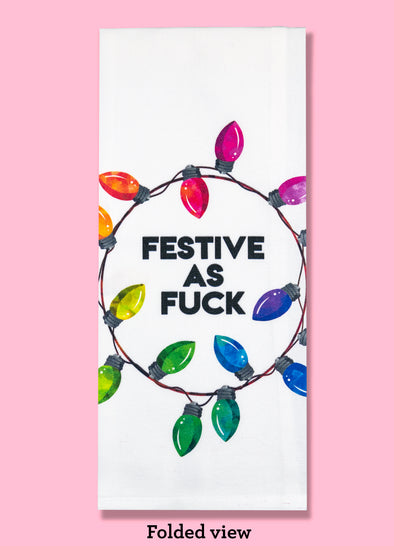 Folded dishtowel with an illustration of a string of Christmas Lights and the phrase Festive as Fuck.