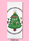 Folded dishtowel with an illustration of a decorated tree and lights and the phrase Fuck Off I'm Decorating.