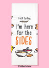 Folded dishtowel with illustrations of Thanksgiving foods and the phrase Fuck Turkey I'm Here For the Sides.