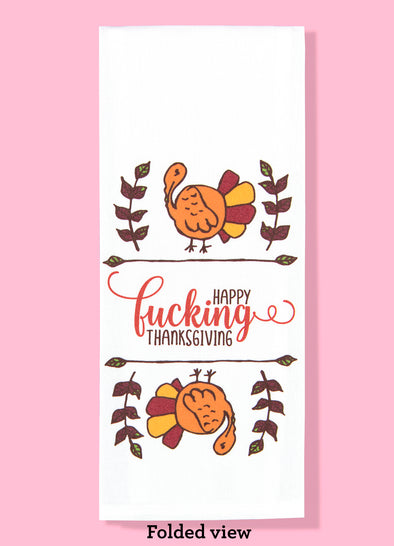 Folded dishtowels with illustrations of two tom turkeys and the phrase Happy Fucking Thanksgiving.