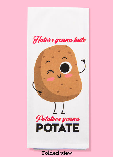 Folded dishtowel with an illustration of a smiling and waving russet potato and the phrase Haters Gonna Hate Potatoes Gonna Potate.