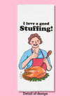 Folded dishtowel with an illustration of a smiling person giving the thumbs up gesture in front of a cooked turkey overflowing with stuffing. Above the illustration is the phrase I Love a Good Stuffing.