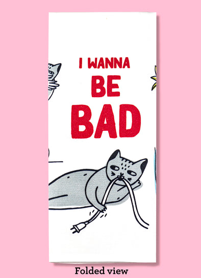 Folded dishtowel with illustrations of cats doing bad things and the phrase I Wanna Be Bad.