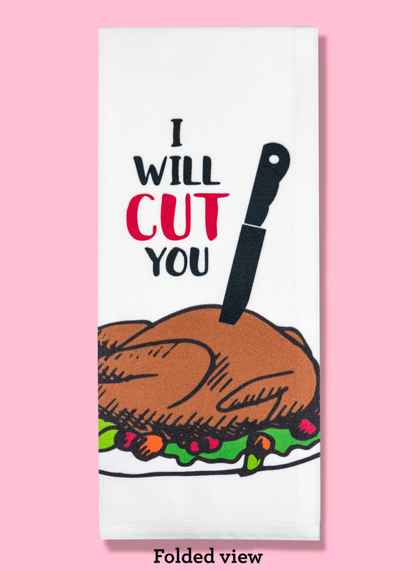 Folded dishtowel with an illustration of a massive black knife sticking into a cooked Thanksgiving turkey and the phrase I Will Cut You.
