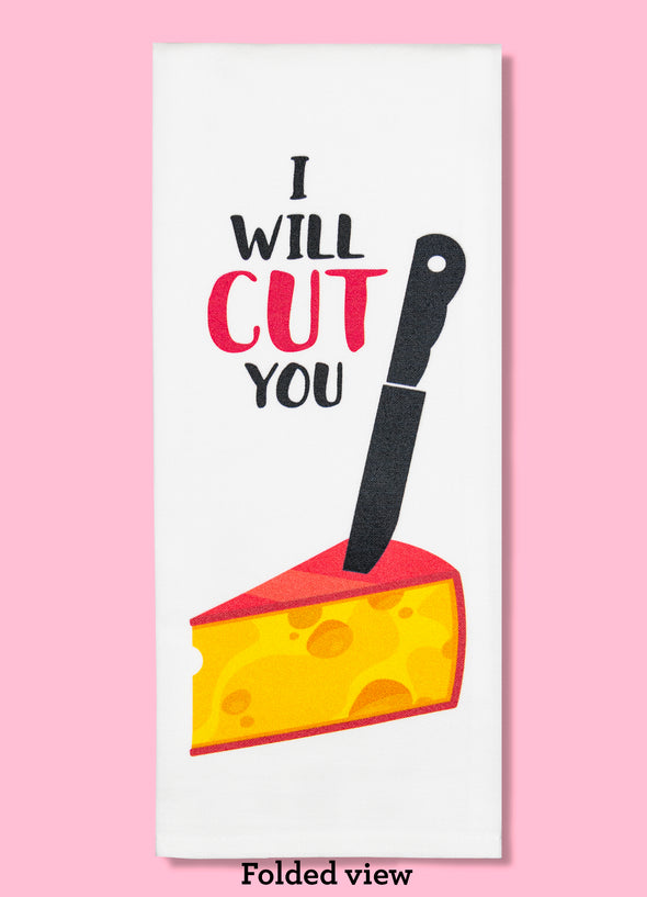 Folded dishtowel with an illustration of a massive black knife sticking into a wedge of cheese and the phrase I Will Cut You.