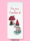 Folded dishtowel with an illustration of a shirtless garden gnome in front of a mushroom house with the phrase I'm Sexy and I Gnome It.