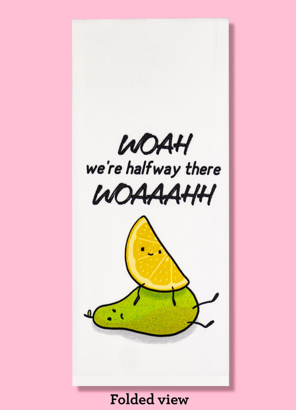 Folded dishtowel with an illustration of a smiling lemon wedge sitting atom a frowning pear with the phrase Woah We're Halfway There Woaaahh.