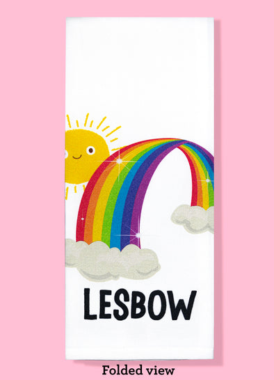 Folded dishtowel of a smiling sun peeking out behind a rainbow with the phrase Lesbow.