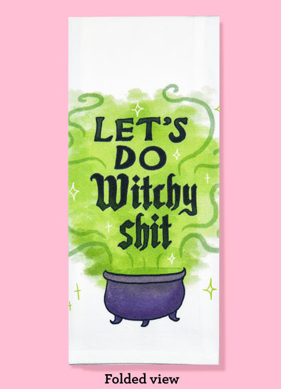 Folded dishtowel of a cauldron with green smoke coming out of it and the phrase Let's Do Witchy Shit.
