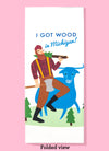 Folded dishtowel with an illustration of Paul Bunyan and Babe the Blue Ox. Bunyan has a tree slung over his shoulder. Above him is the phrase I Got Wood in Michigan.