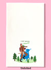 Unfolded dishtowel with an illustration of Paul Bunyan and Babe the Blue Ox. Bunyan has a tree slung over his shoulder. Above him is the phrase I Got Wood in Michigan.