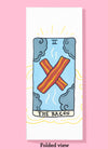 Folded dishtowel of an illustration of a faux tarot card featuring two cooked bacon strips in an X formation surrounded by 4 clouds with the phrase The Bacon