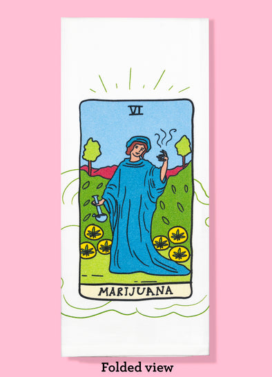 Folded dishtowel with a tarot card like illustration of a berobed person holding a glass pipe and a smoking rolled cigarette. The bottom of the card says Marijuana.