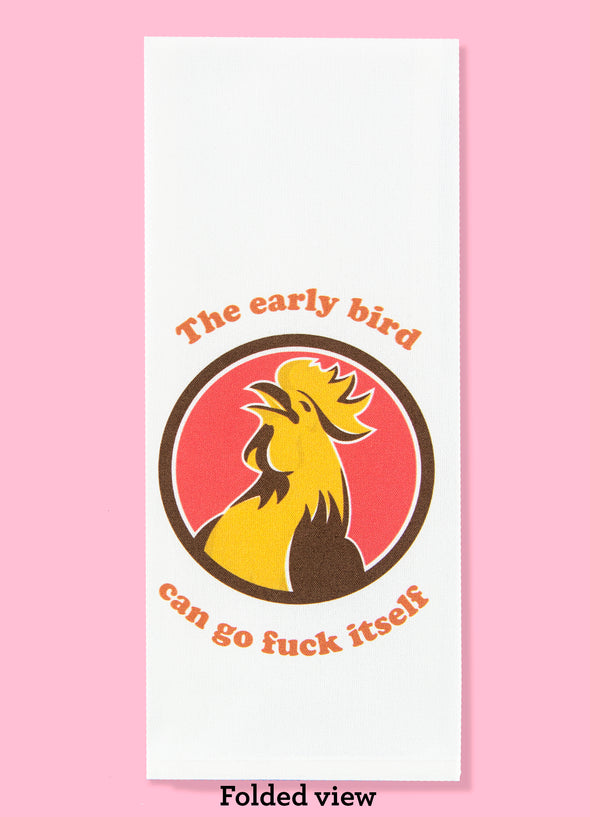 Folded dishtowel with the phrase the early bird can go fuck itself with an illustration of a cartoon rooster looking as though he's laughing