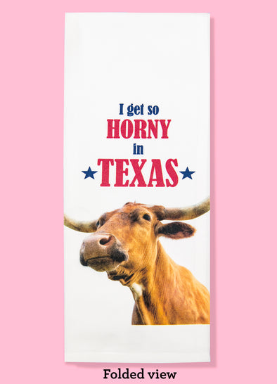 Folded dishtowel with an illustration of a Longhorn bull with the phrase I Get So Horny in Texas.