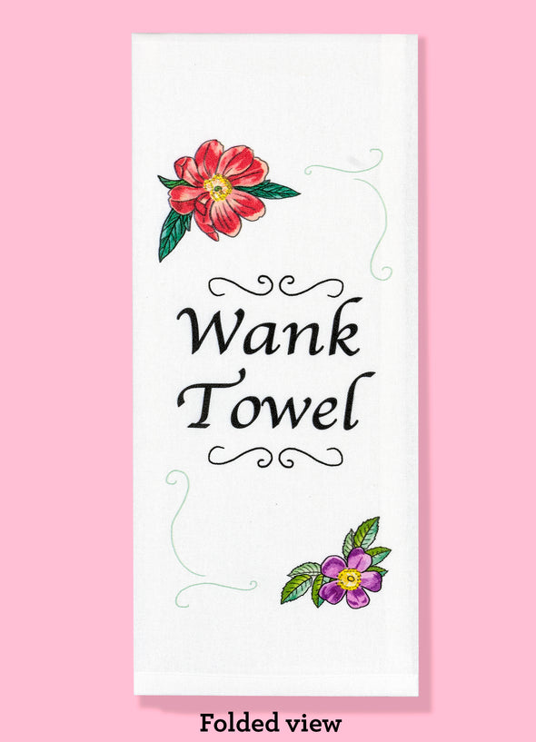 Folded dishtowel with the phrase wank towel. The text is surrounded by illustrations of flowers in the upper left and lower right of the design and black squiggles in the upper right and lower left