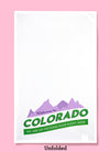 An unfolded view of the design of welcome to Colorado we are so fucking high right now. The illustration is purple mountains with weclcome to on it. The rest of the text is in green below the mountains.