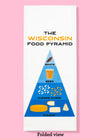 Folded dishtowel with the phrase the Wisconsin food pyramid. The illustration features pyramid, similar to the USDA food pyramid, with 4 levels: The first has an illustration of a bratwurst saying brats, the second has an illustration of a glass of beer saying beer, the third has illustrations of cheese curds and says cheese curds, the fourth has illustrations of various cheese and says cheese.