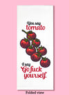 Folded dishtowel with the phrase you say tomato I say go fuck yourself in black and red text with an illustration of tomatoes on the vine