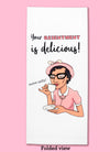 Folded dishtowel with the phrase Your Resentment is Delicious!. The illustration shows a woman sipping tea with an illustration of her saying mmm salty!.